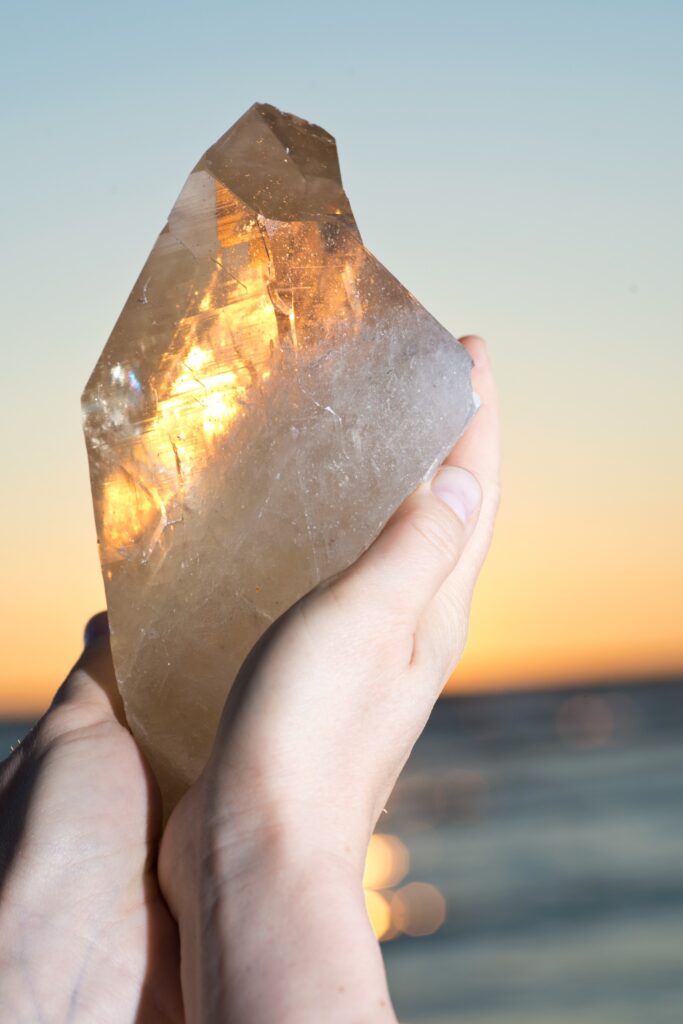 Une main tenant une pierre et l'exposant à la lumière du soleil.