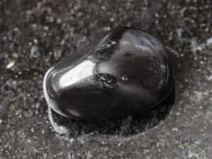 une pierre obsidienne noire polie rond sur une table en marbre noir