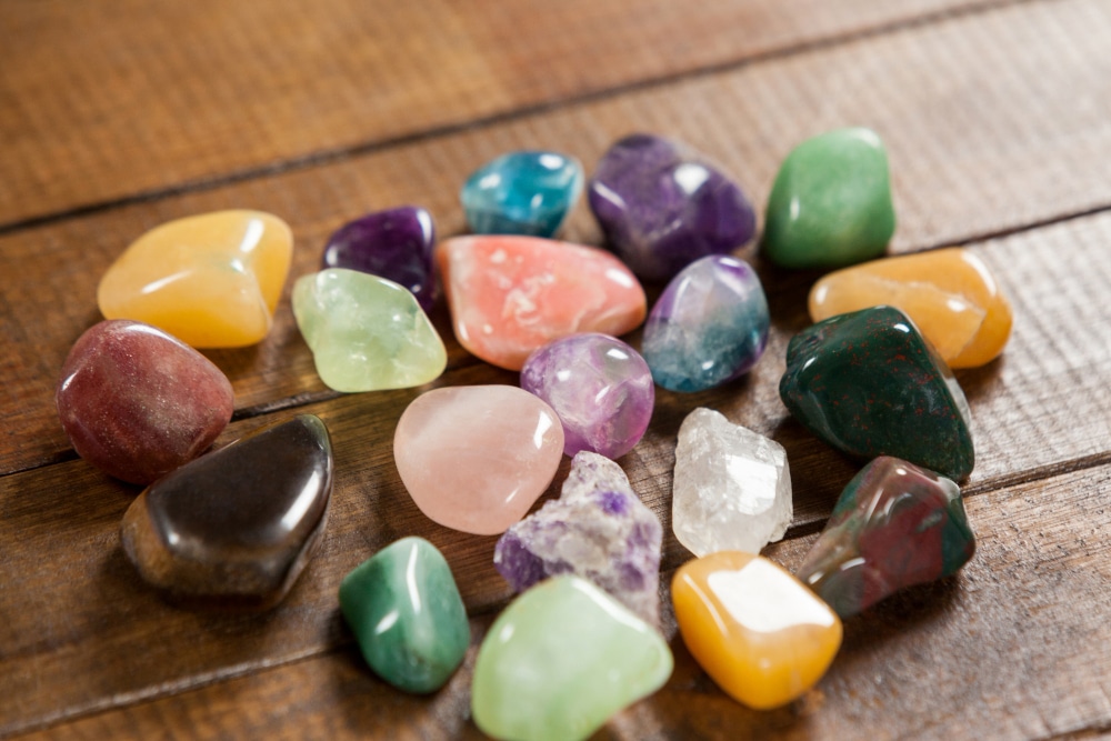 des pierres de différentes couleurs posées sur une table en bois